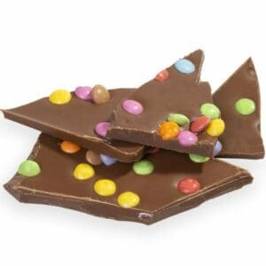Homemade Chocolate Confetti Slab crafted from the finest milk chocolate and dotted with colorful mini-Smarties. Expertly blended by our Master Chocolatiers, this slab offers a delightful blend of creamy chocolate and playful crunch. A radiant choice for sharing, personal treat, or gifting, it's a vibrant celebration of flavors in every bite.