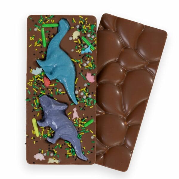 Unleash your inner Jurassic adventurer with our Dinosaur Bar – the milk chocolate bar that will have you roaring with delight! This prehistoric masterpiece is a creamy milk chocolate wonderland, filled with adorable edible white chocolate dinosaurs just waiting to be devoured. And if that wasn’t enough to satisfy your dino cravings, the bar is also sprinkled with colorful sprinkles, adding a touch of magic to your chocolate experience. With each bite, you’ll feel transported to a land before time, where the chocolate is sweet and the dinosaurs are even sweeter. So whether you’re a T-Rex or a triceratops, sink your teeth into our Dinosaur Bar and taste the excitement. The perfect gift!